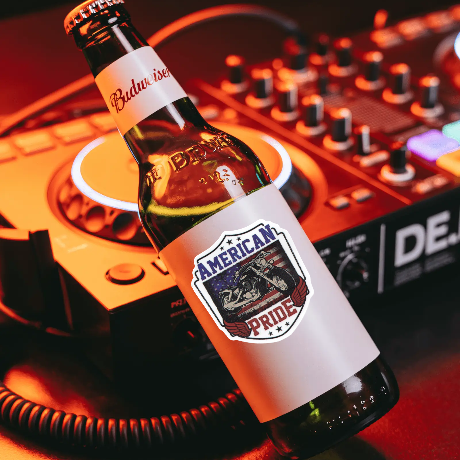 Budweiser beer bottle with 'American Pride' label on a DJ mixer