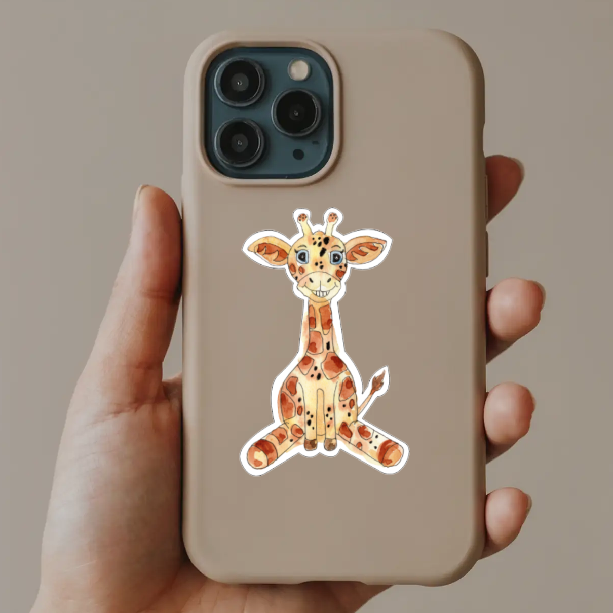 Phone case with a giraffe design held by a hand against a neutral background