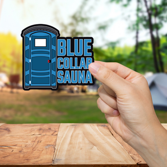 Hand holding a 'Blue Collar Sauna' sticker with a blurred outdoor background