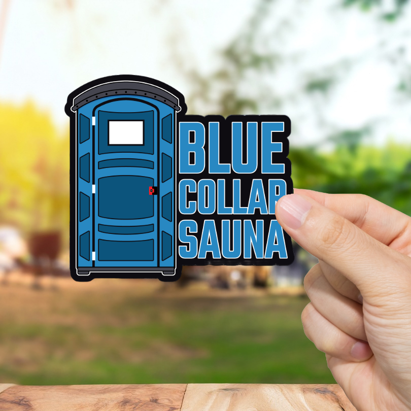 Hand holding a 'Blue Collar Sauna' sticker with a blurred outdoor background