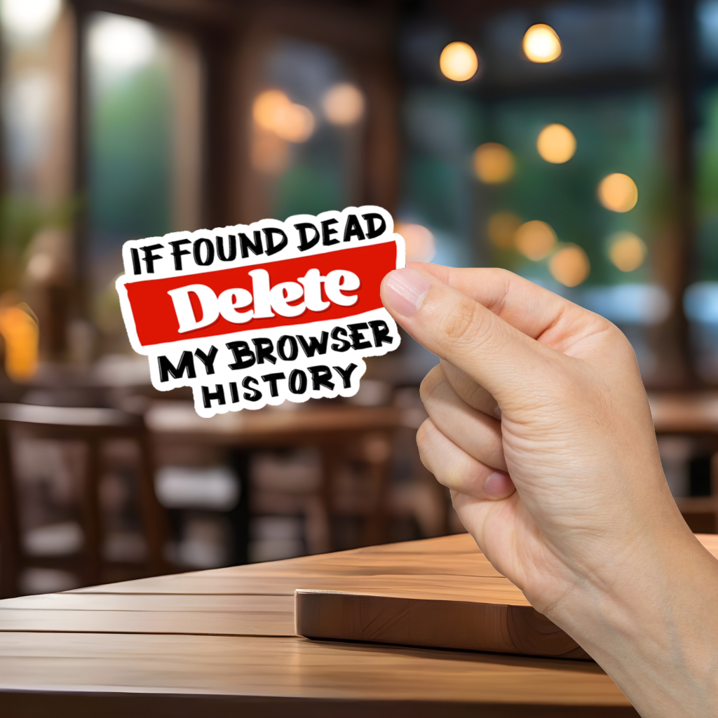 Hand holding a sticker with text 'If Found Dead, Delete My Browser History' in a blurred cafe setting