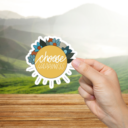 Hand holding a 'Choose Happiness' sticker with a scenic background