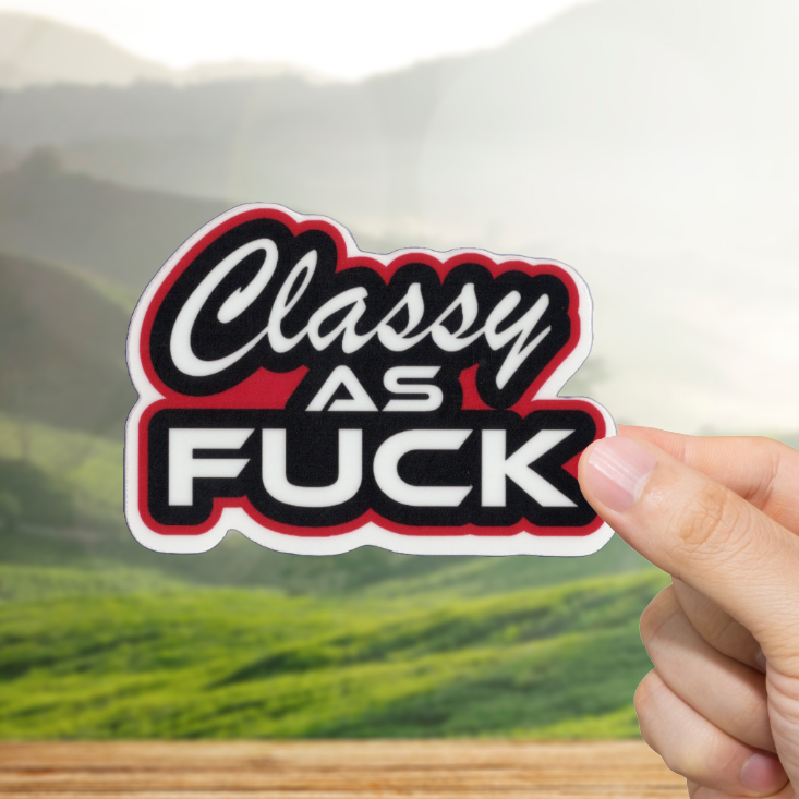 Hand holding a 'Classy as Fuck' sticker with a scenic background