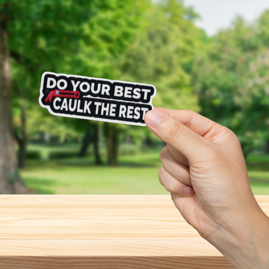 Hand holding a sticker with text 'Do your best, caulk the rest' against a blurred green outdoor background