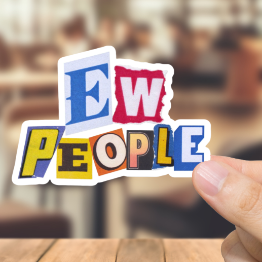 Hand holding a colorful sign with 'EW PEOPLE' text in a blurred restaurant setting