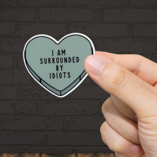 Durable, vinyl, die-cut, Surrounded By Idiots Sticker.